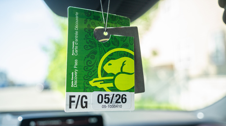 A Parks Canada Discovery Pass hanging from the rearview mirror of a car