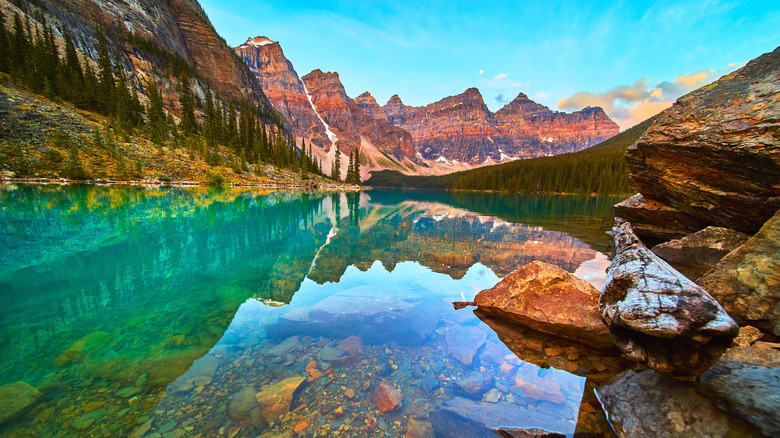 The clear, turquoise waters of Moraine Lake in Banff National Park at sunrise