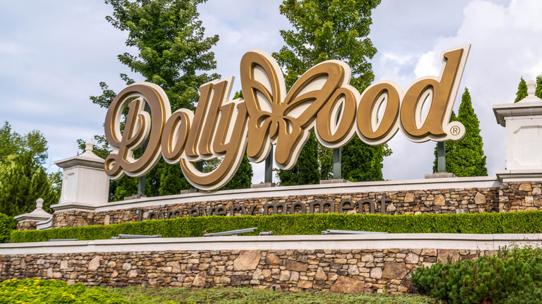 Gold script "Dollywood" entry sign outside of Dollywood theme park in Pigeon Forge, Tennessee