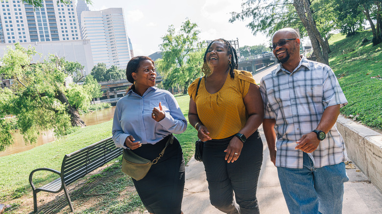 Three people talking and laughing in a public park