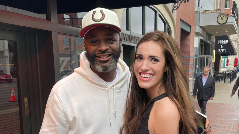 Brunette woman poses with legendary Colts wide receiver Reggie Wayne outside of St. Elmo Steak House in downtown Indianapolis, IN