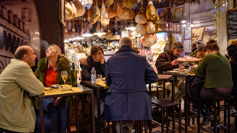 A busy restaurant at night in Bologna