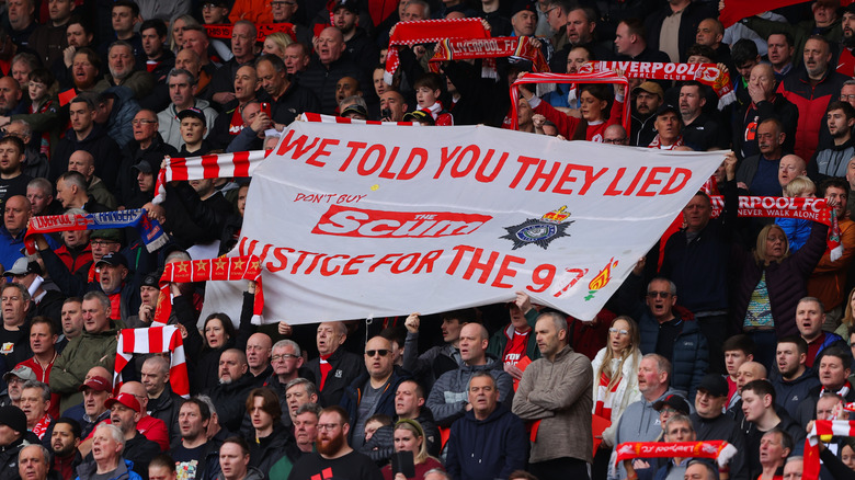 Liverpool supporters lift a banner in remembrance of the 1989 Hillsborough disaster and against The Sun newspaper