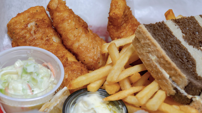 Typical Friday night fish fry in Wisconsin featuring fried cod, french fries, coleslaw, tartar sauce, and marbled rye bread in a baske