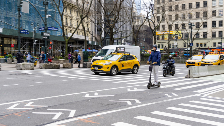 A man zipping around New York City on an electric scooter