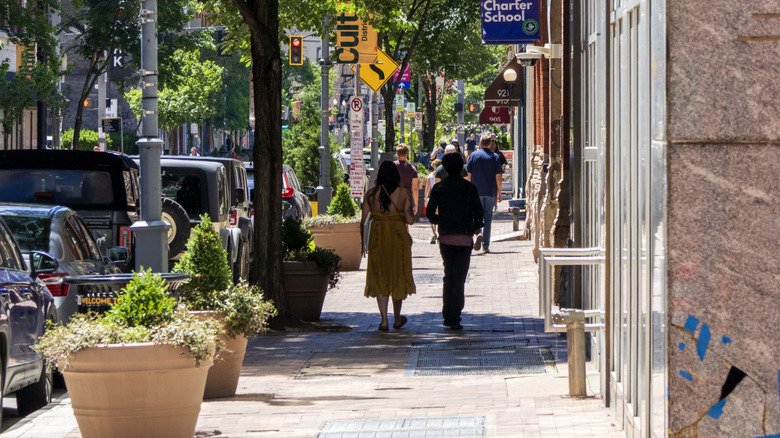 People walk down the sidewalk in the Culture District of downtown Pittsburgh on a sunny day