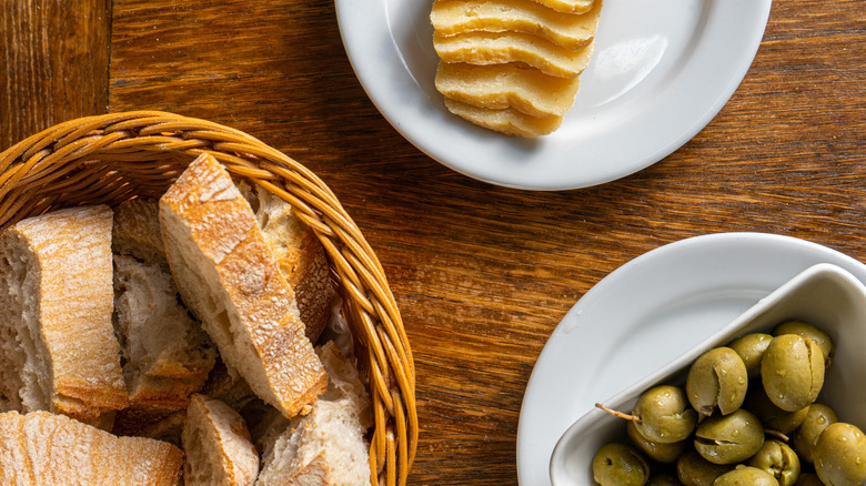 Rustic Alentejo restaurant table showcasing green olives, Alentejo cheese, and traditional bread