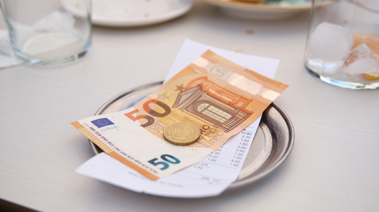 Metal change tray with the bill and 50 euro note and coins