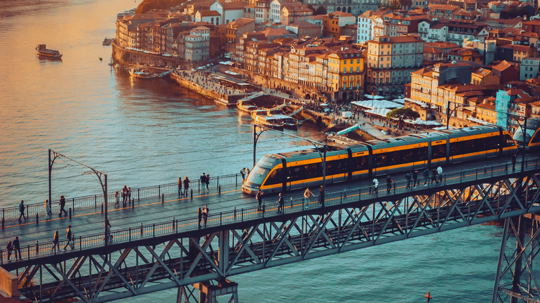 Porto, Portugal Dom Luis Iron Bridge at sunset featuring Douro River, Metro Train, and Port Wine Boats