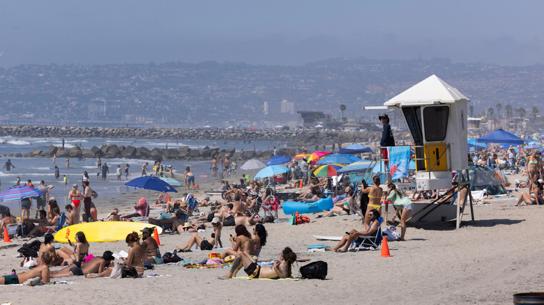 People laying on sand at Ocean Beach in San Diego