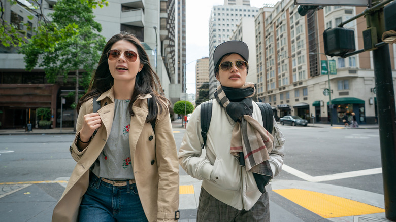 Two Asian women wearing jackets and scarves as they walk through downtown San Francisco
