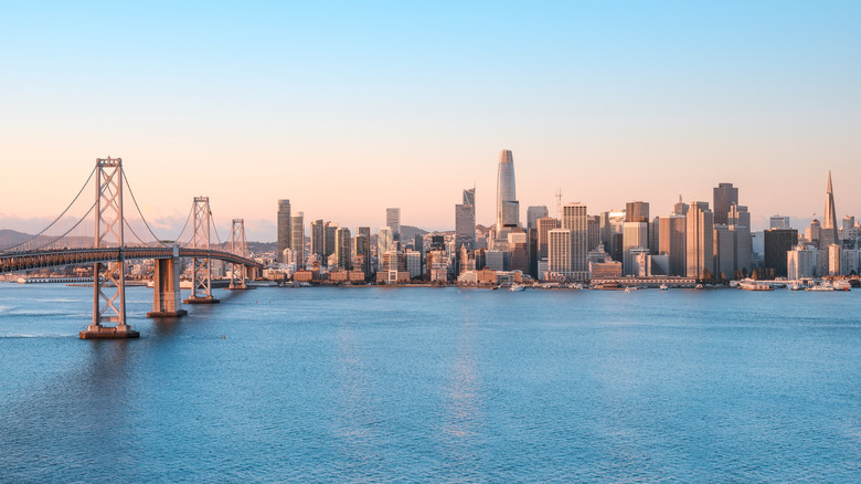 A view of the San Francisco skyline and Bay Bridge against a clear evening sky