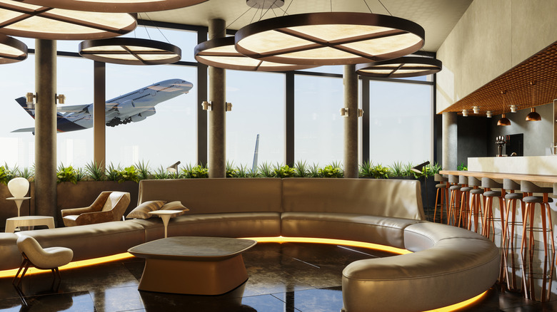 Empty airport lounge with plane taking off in background