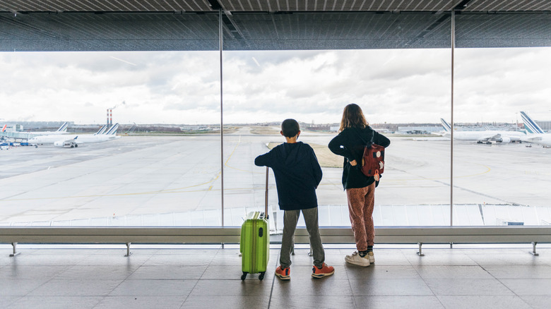 Children looking at window in airport