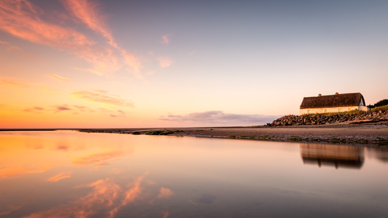 Bettystown Beach at sunrise with orange clouds reflecting on water