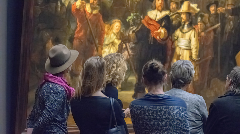 Visitors to the Rijksmuseum gaze at Rembrandt's Nightwatch