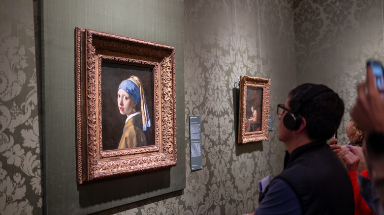 Visitor looks at "Girl with Pearl Earring" at Mauritshuis