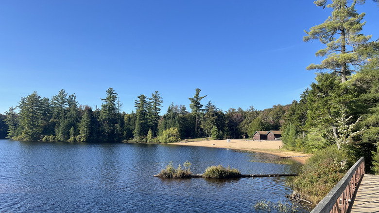 Water laps beach leading to campground at Nicks Lake in Old Forge, New York