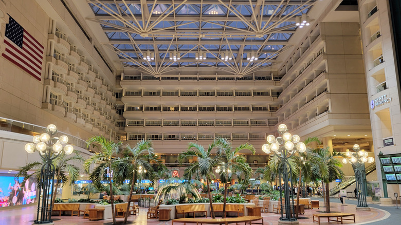 View of Hyatt Regency sign (on righthand side) and guest room balconies overlooking the palm tree atrium at Orlando International Airport