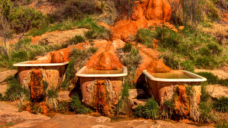 bathtubs covered in red mineral deposits at Utah's Mystic Hot Springs