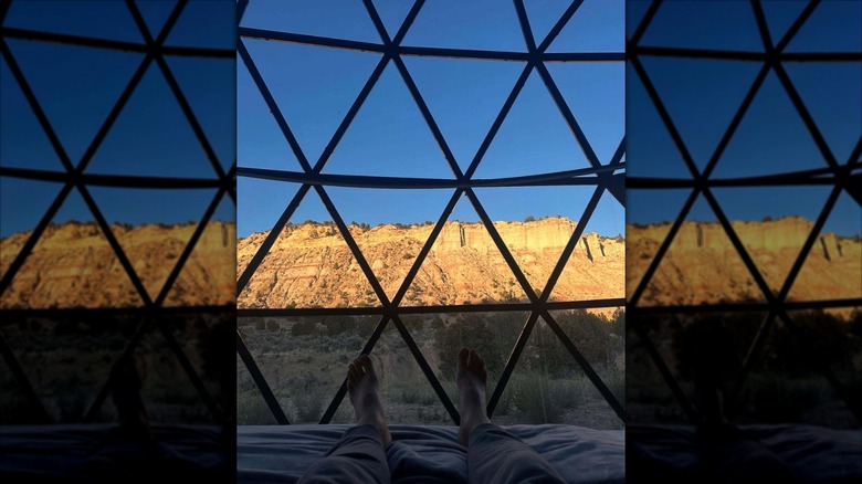 An image of a guest lying down inside a glass dome at Clear Sky Resorts Bryce Canyon with the view of Bryce Canyon
