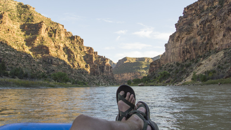 Someone's feet lounging on the Green River in Desolation Canyon