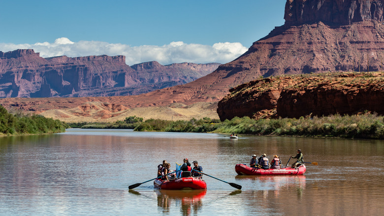 Two groups in red rafts floating through calm canyons
