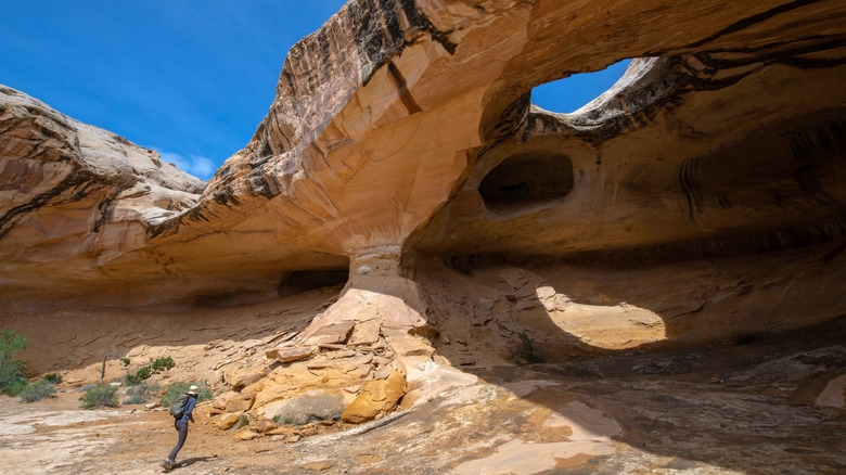 A hiker at Utah's Wild Horse Window, a natural bridge located in the southeastern section of the San Rafael Swell