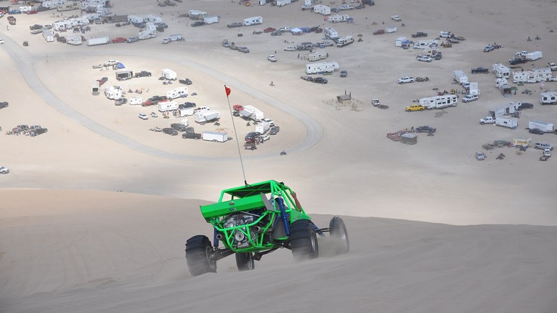 Off road vehicle on sand dunes near RVs