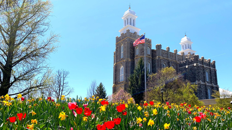 The Logan Utah Temple of the Church of Jesus Christ of Latter-Day Saints with colorful flowers in the front