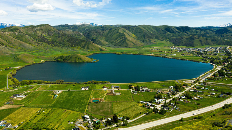 Aerial view of the Mantua Reservoir in Utah, surrounded by green fields