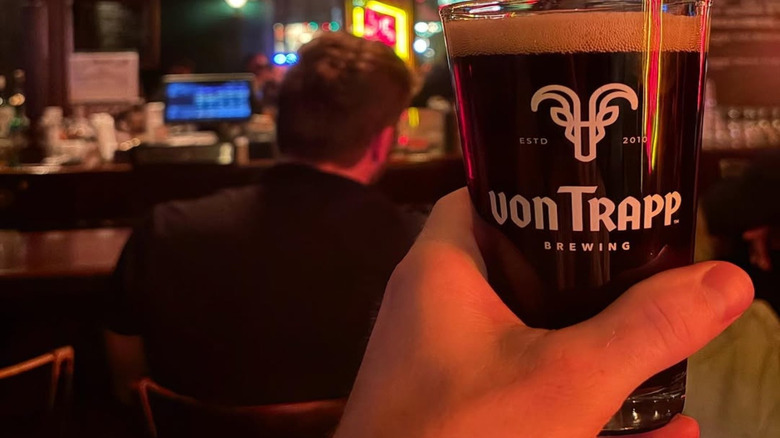 Hand holding a glass of beer at the bar at von Trapp Brewing in Stowe, Vermont