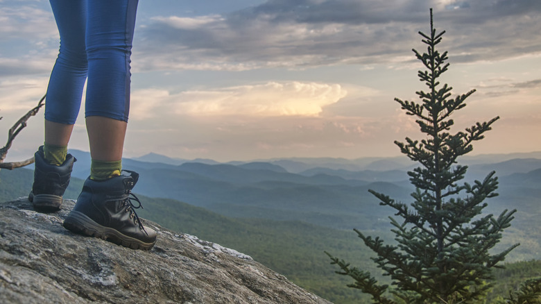 Feet in hiking boots standing on a Vermont mountain
