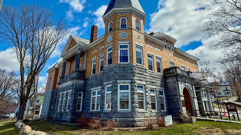 The brick and stone facade of the Haskell Free Library looks bright on a sunny spring day in Derby, Vermont