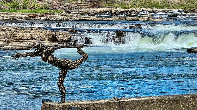 Sculpture stands next to Winooski Falls