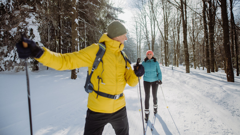 Couple cross-country skiing in the forest