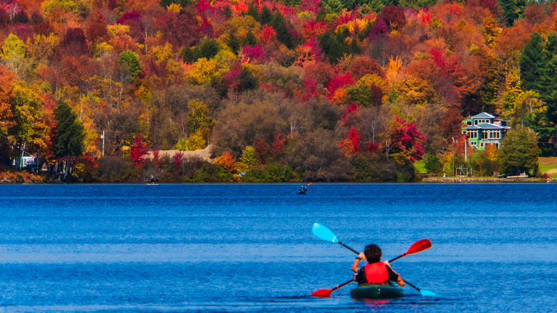 Kayakers on a lake framed by fall foliage in Elmore, Vermont