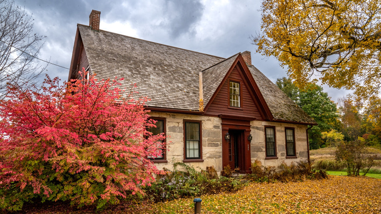 Fall foliage surrounds the Robert Frost house in Shaftsbury Vermont in shades of gold, orange, and red
