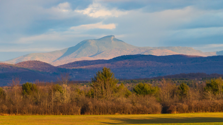 The setting sun lights up Camels Hump Mountain in late fall in the Vermont Green Mountains