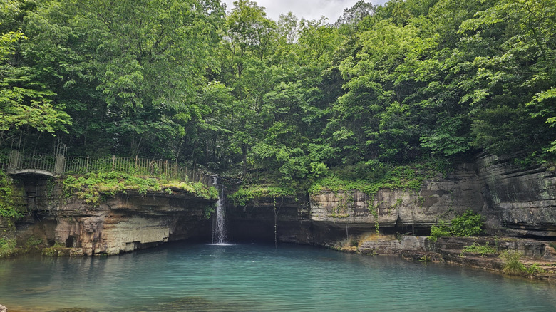 limestone bluffs, and a pool of azure water, surrounded by greenery at Dogwood Canyon Nature Park, Missouri