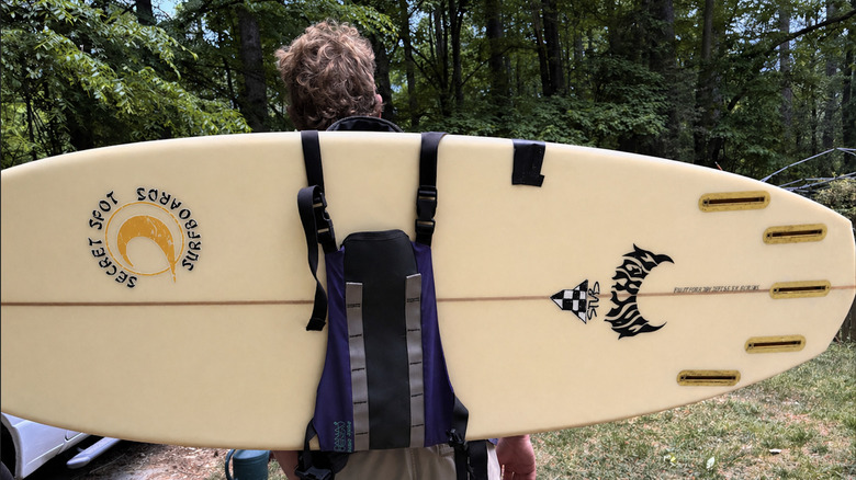 Kenan Dudley carrys his surfboard using a Dana Design backpack
