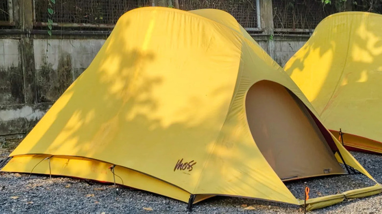 A yellow Star Gazer tent from Moss Tents set up on a gravel campsite