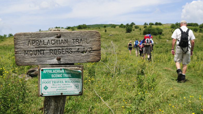Appalachian trail sign in Virginia with hikers on it.