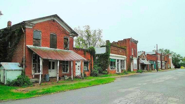 Abandoned brick buildings along a street in downtown Pamplin, under a blue sky