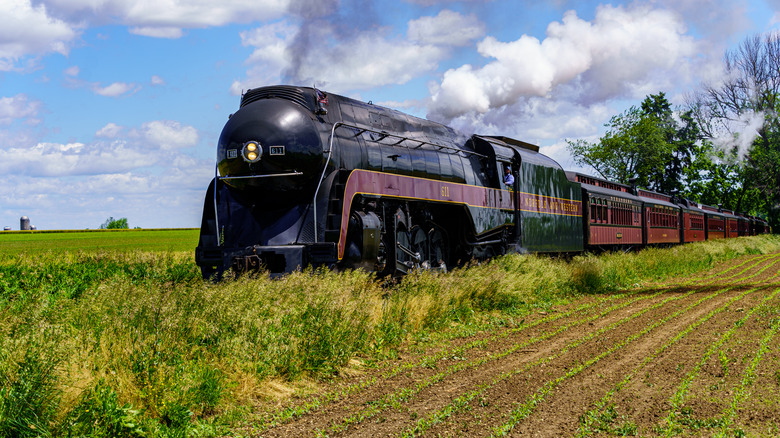 Norfolk & Western Class J 611 locomotive chugging through the countryside