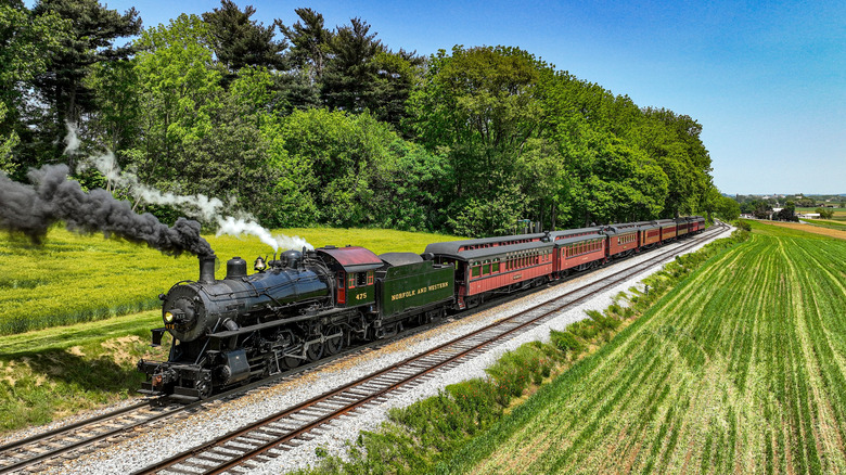 A Norfolk & Western locomotive steaming along a railroad track