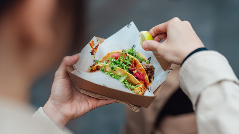 Close up of a person eating tacos