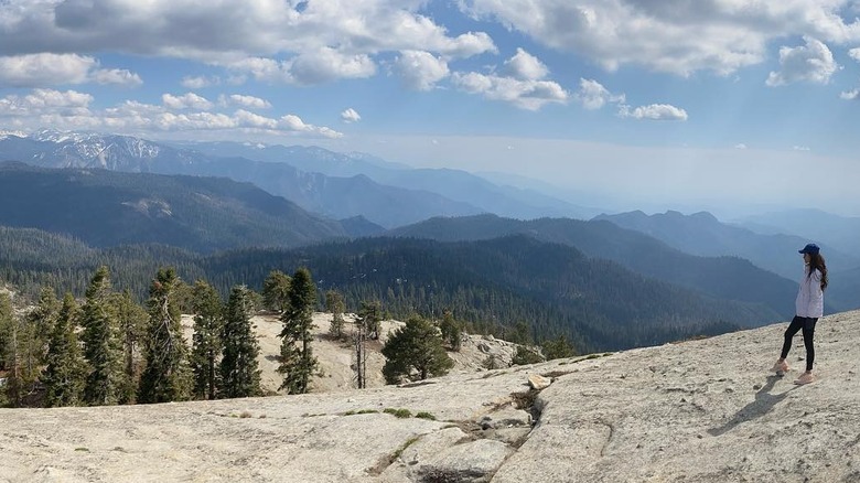 Hiker enjoying vIews of mountain ranges from the summit of the Little Baldy Trail in Sequoia National Park