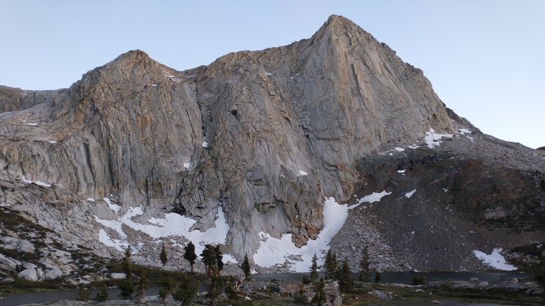 Alpine landscape of Mineral King in Sequoia National Park with craggy peaks, sparse trees, lake, and clouds at eye level
