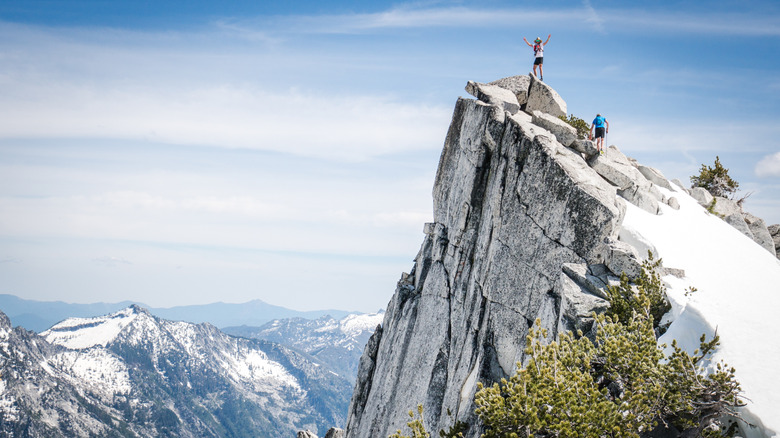 A mountaineer climbs to the top of a summit in California's Trinity Alps